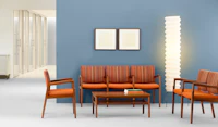 A waiting room with blue wall featuring Monarch Multiple seating in orange and striped textile.
