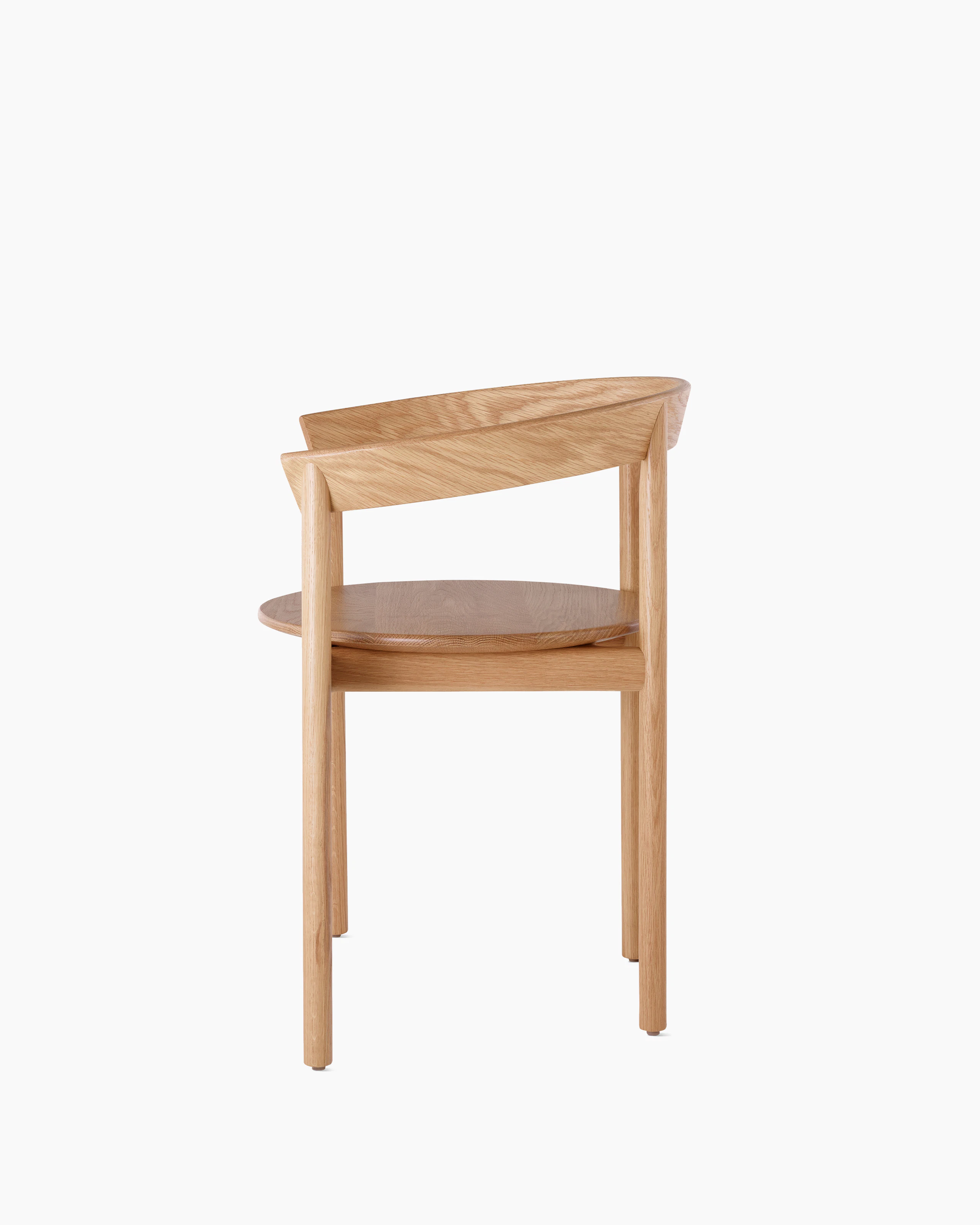 Profile view of an oak Comma Chair with arms.