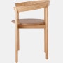 Profile view of an oak Comma Chair with arms.