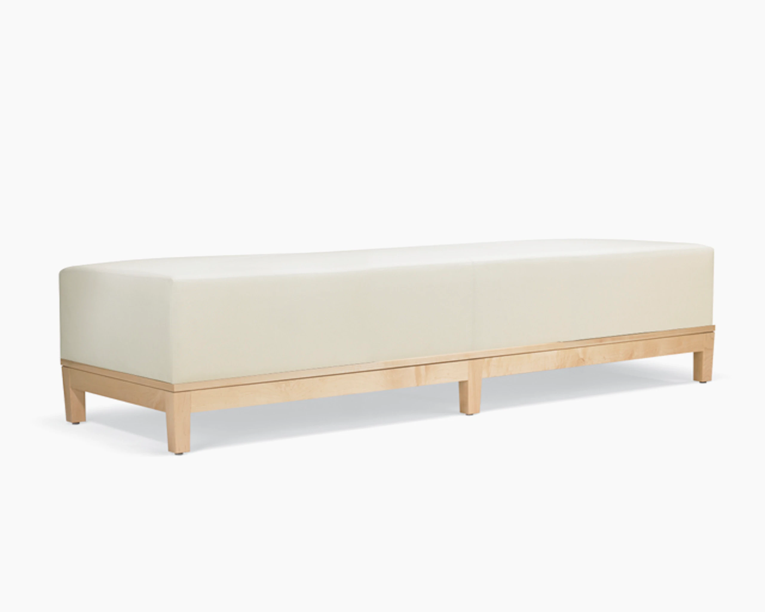 A three-quarter view of a Brava Platform Lounge Bench with maple base and white textile.