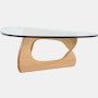 A Noguchi Table with light wood base and glass top.