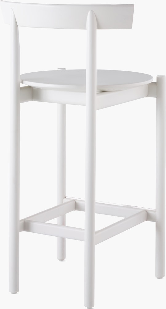A white counter-height Comma Stool, viewed from the back at an angle. 