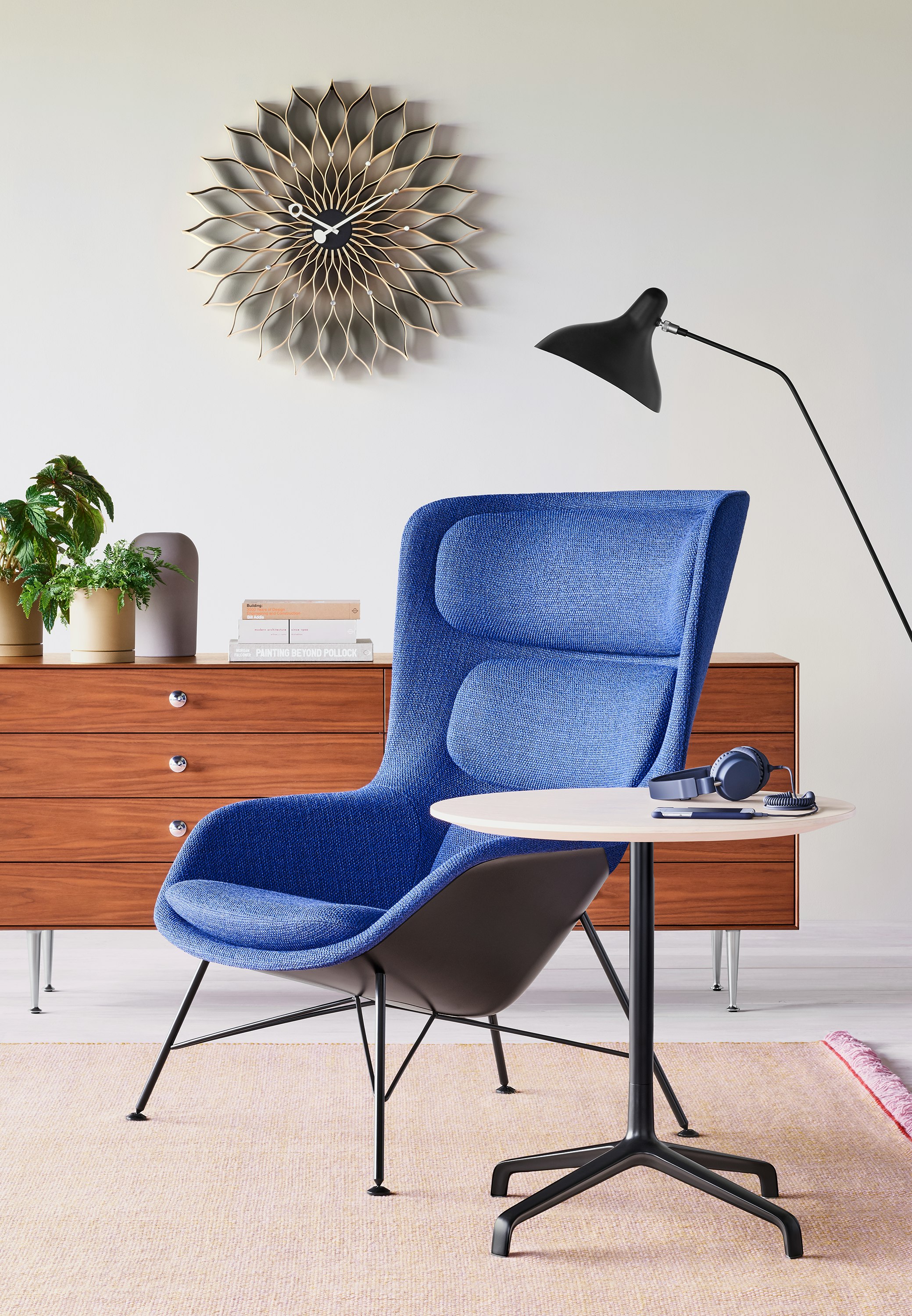 A blue Striad Lounge Chair beside a Striad Table with a white ash top. A Nelson Thin Edge Chest rests in the background.