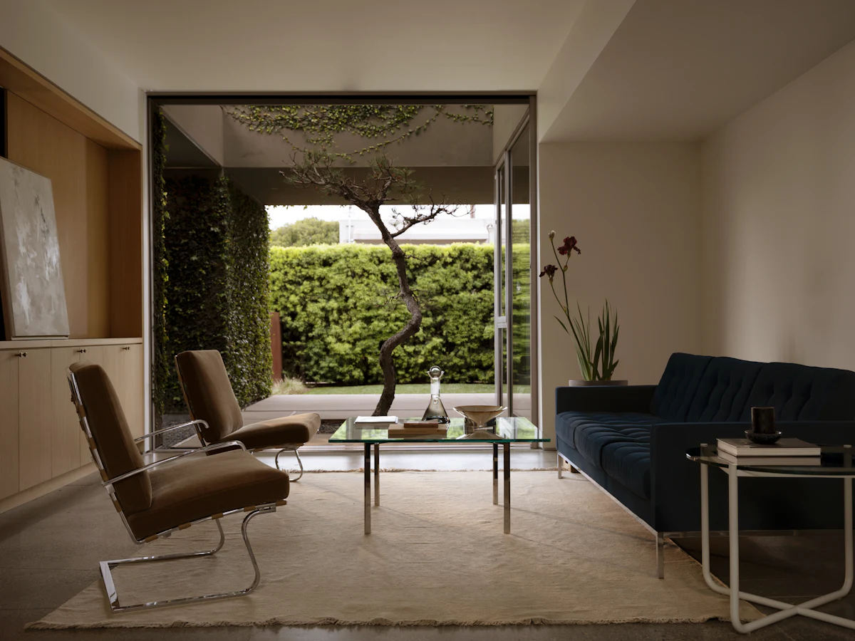 Set of brown modular living room chairs around glass coffee table with metal legs