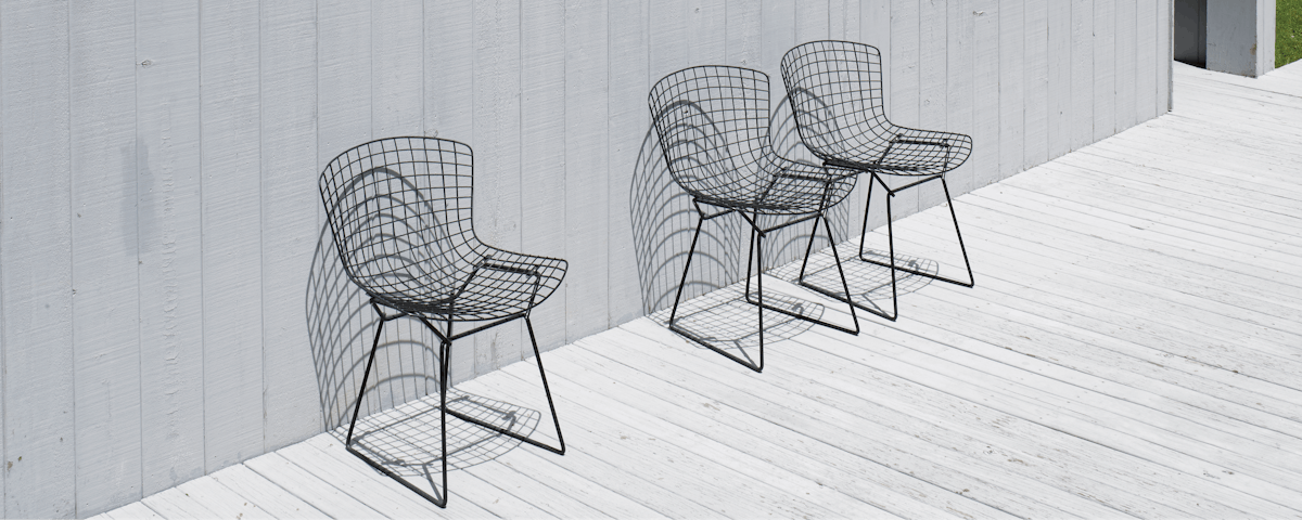 Three Bertoia Side Chairs on an outdoor house deck