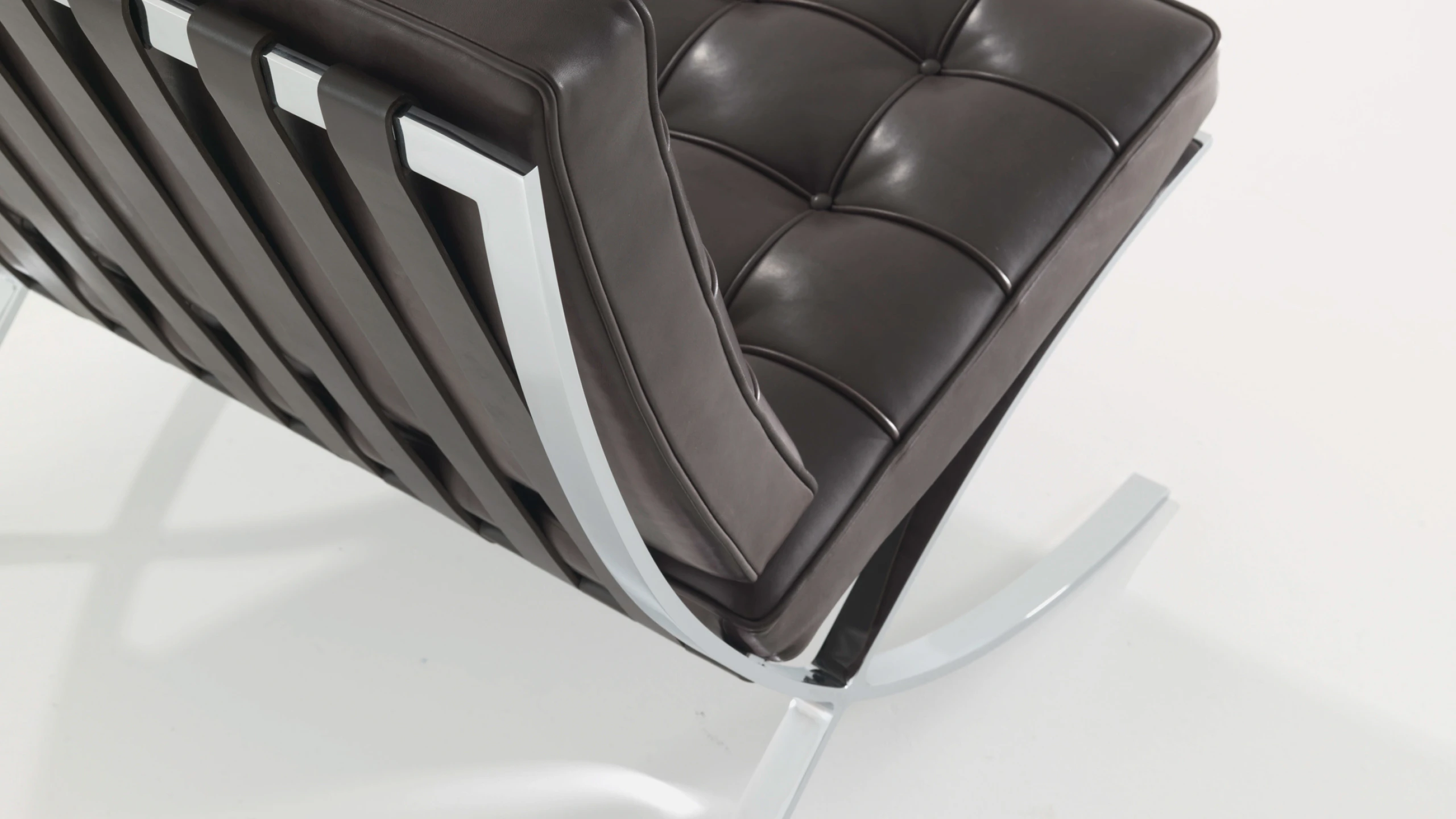 A black Barcelona Chair by Knoll viewed from the back at an angle