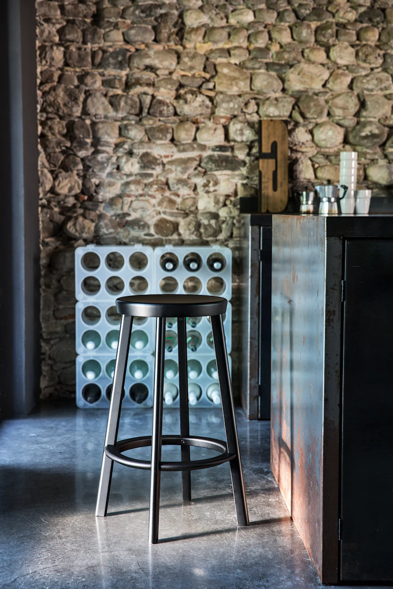 Full view of shiny chrome bar stool with round seat and circular footrest