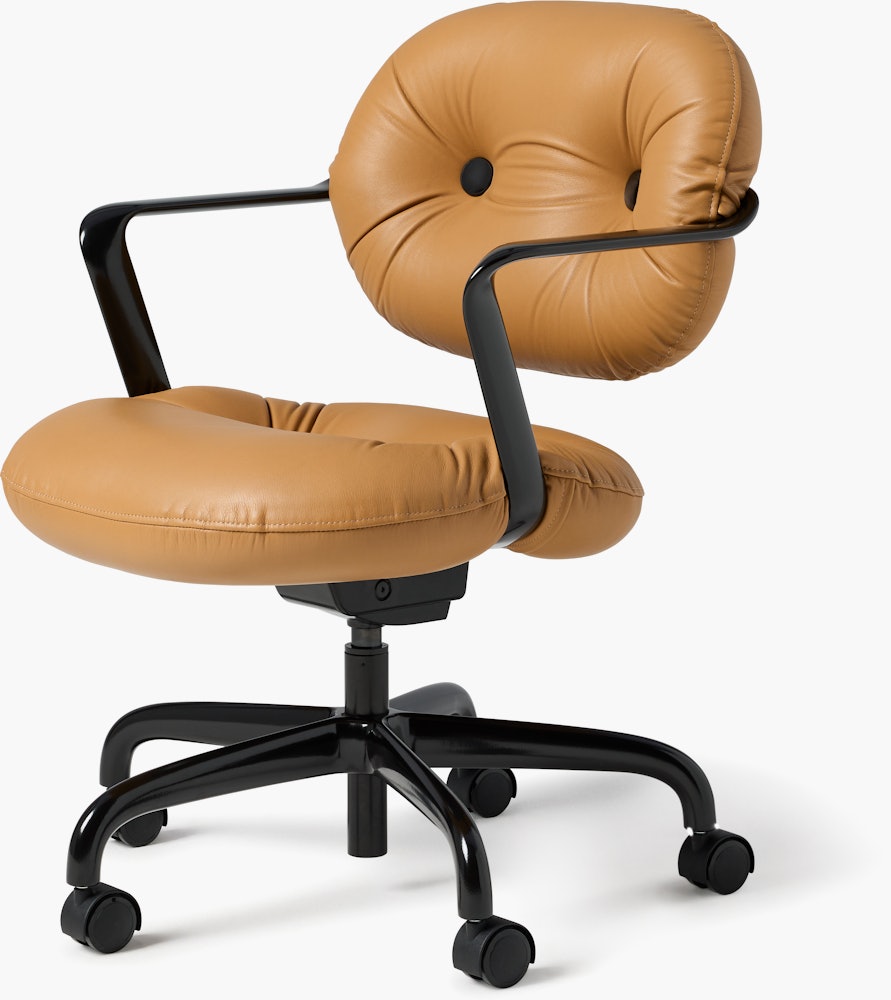 Front angle view of a Morrison Hannah chair with a black frame and base with fixed arms and light brown leather upholstery.