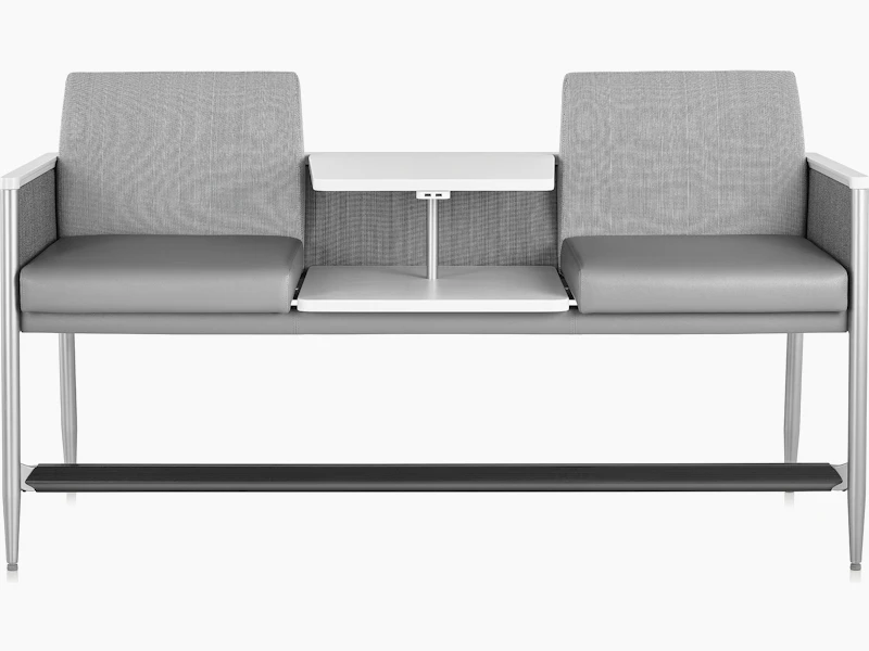 Front view of Palisade Easy Access in a gray upholstery with a height-adjustable center table in white, on white sweep.