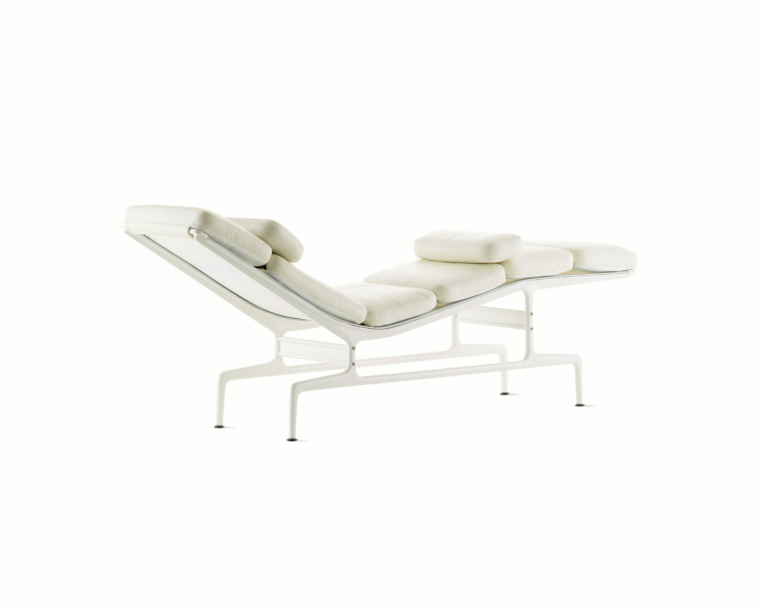 An all-white Eames Chaise, viewed from the back at an angle.