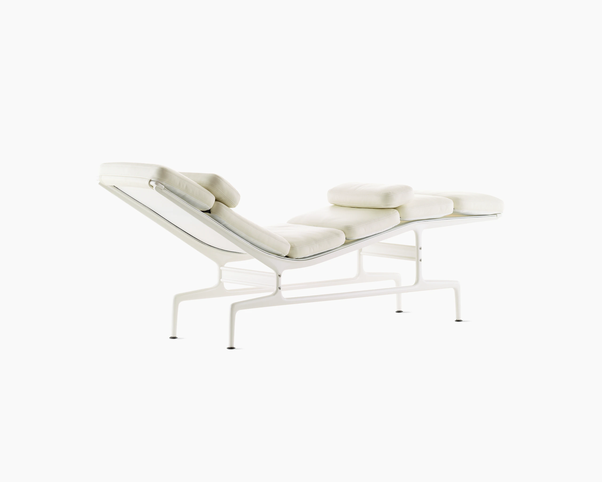 An all-white Eames Chaise, viewed from the back at an angle.