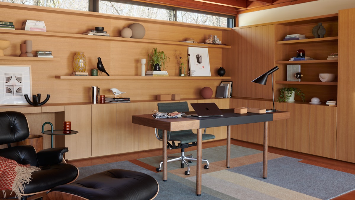 Leatherwrap Sit-to-Stand Desk, Eames Aluminum Group Chair,  AJ Table Lamp and Eames Lounge and Ottoman in home office setting