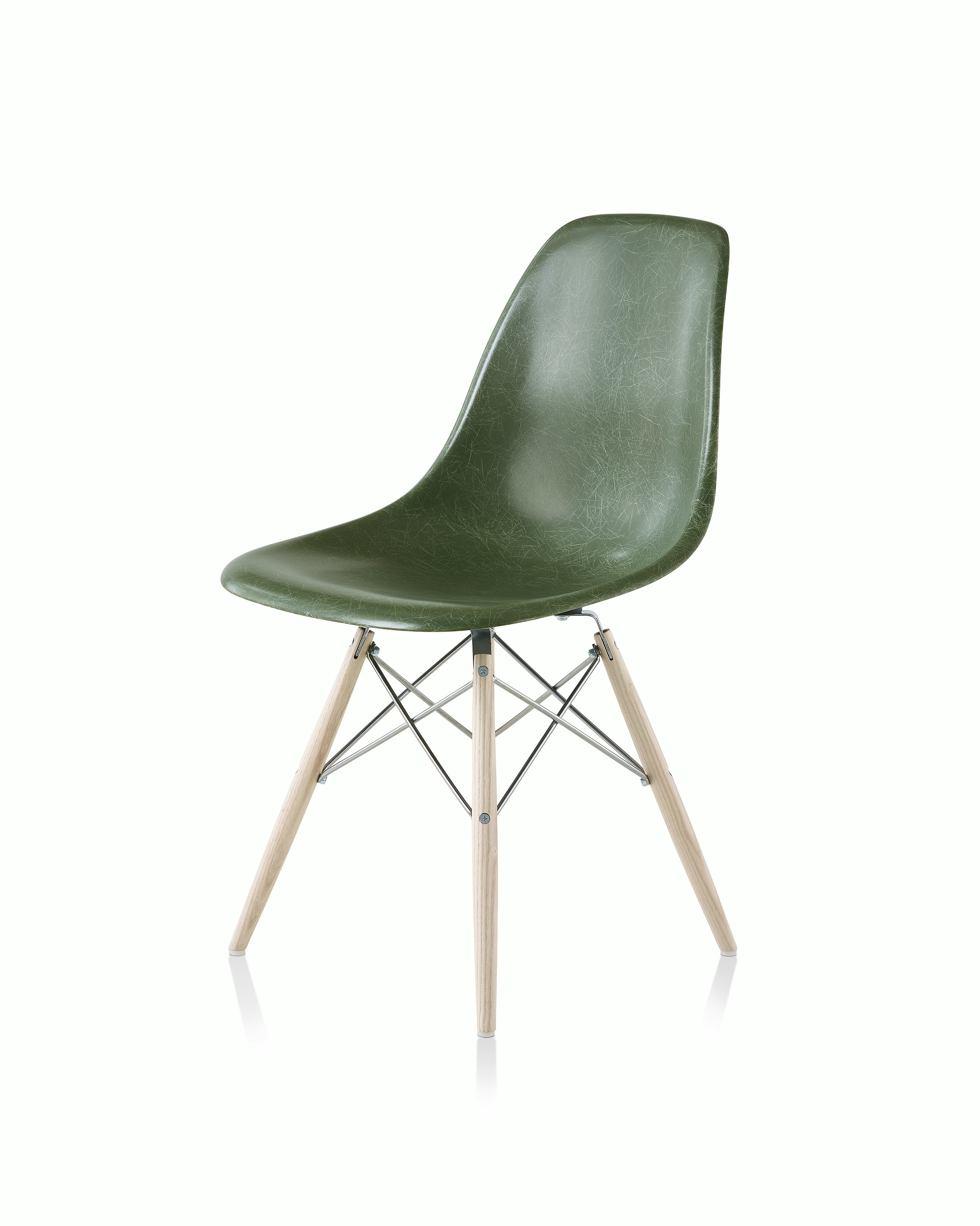 An Eames Molded Fiberglass Side Chair with a dowel base and dark green seat, viewed at an angle.