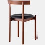 A walnut Comma Chair with a seat pad, viewed from the back at an angle.