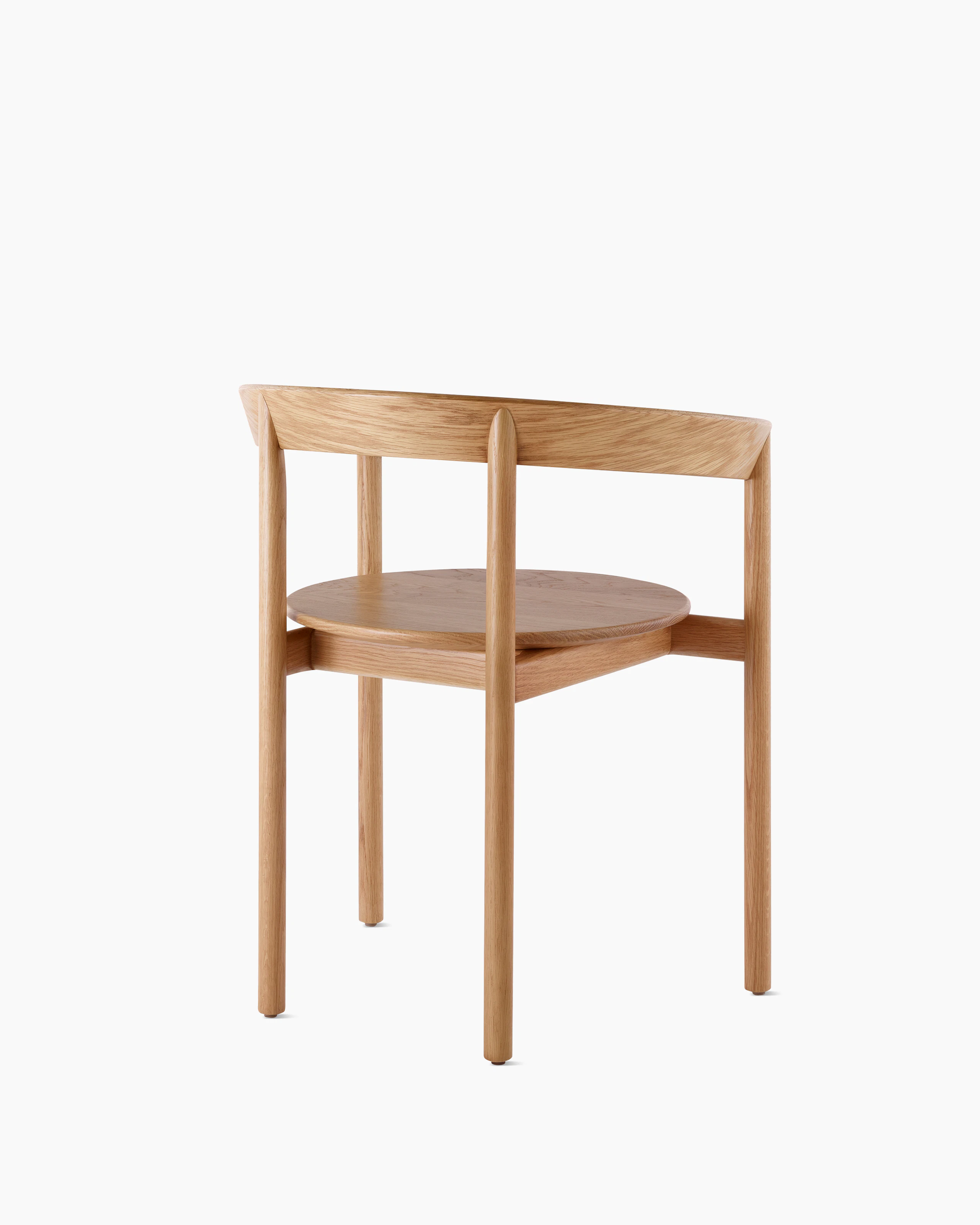 An oak Comma Chair with arms, viewed from the back at an angle.