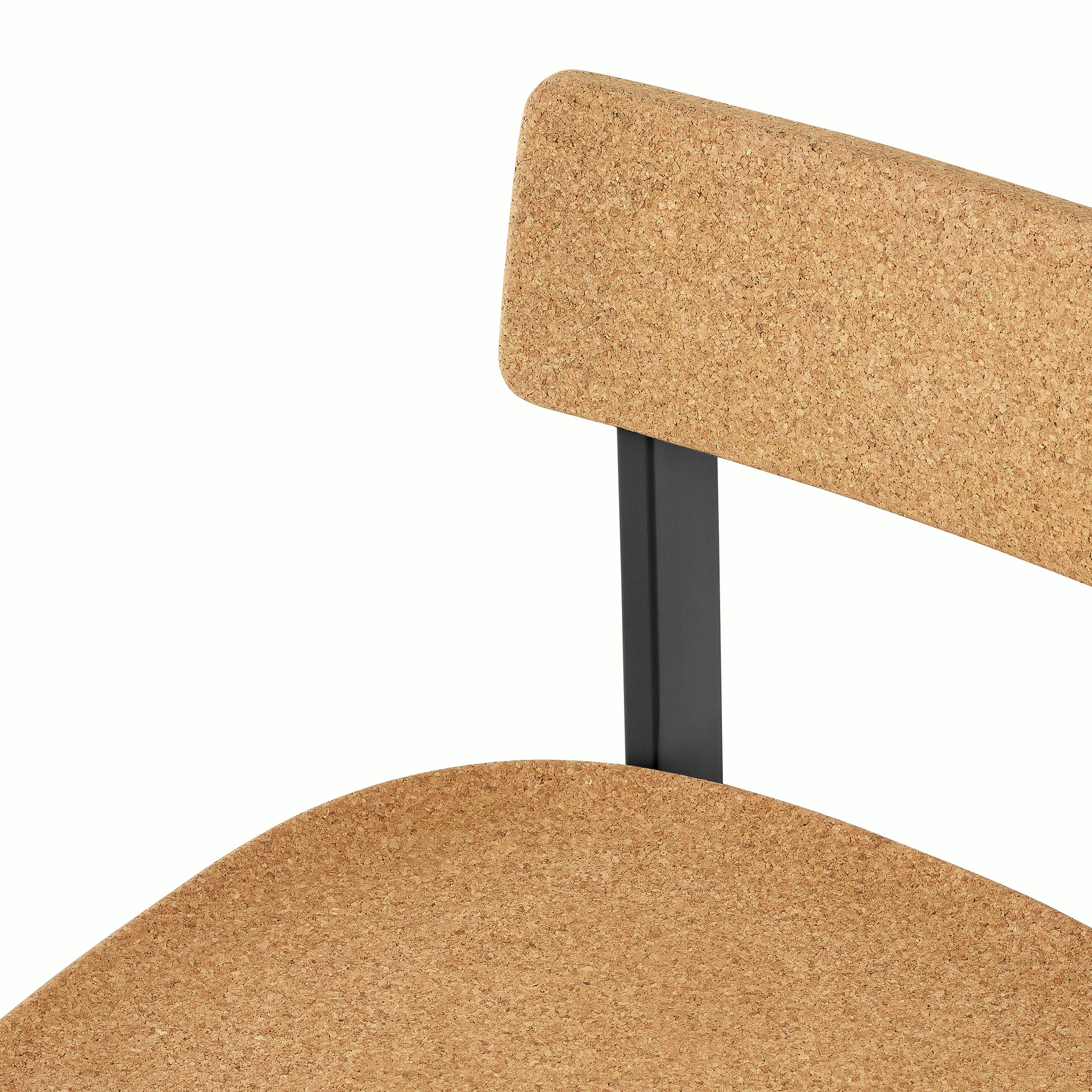 A  close-up of a cork Betwixt Chair with a black frame. 