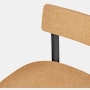 A  close-up of a cork Betwixt Chair with a black frame.