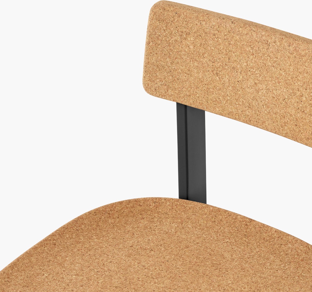 A  close-up of a cork Betwixt Chair with a black frame.