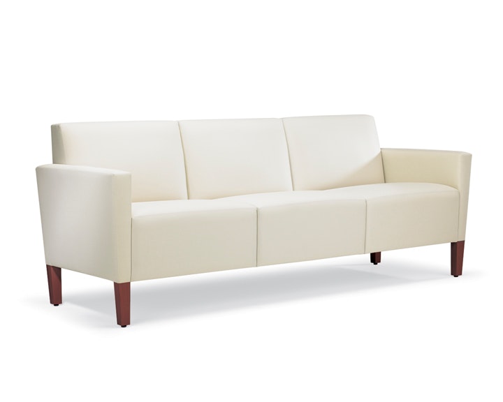 A three-quarter view of a Brava Classic Lounge Sofa with white textile and upholstered arm caps.