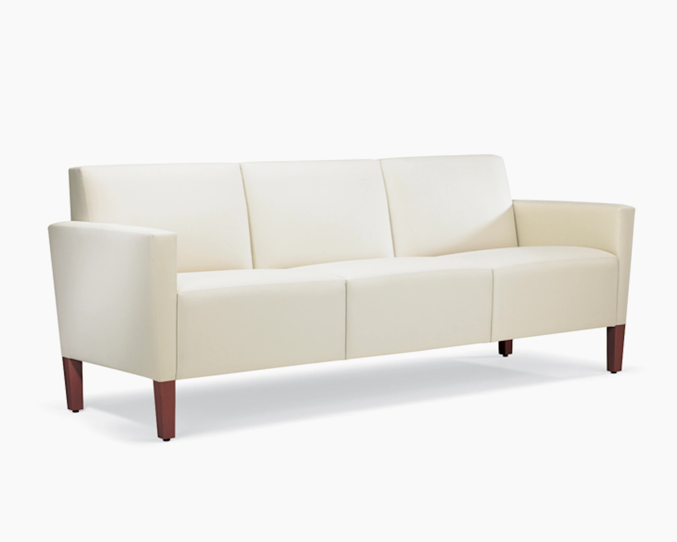 A three-quarter view of a Brava Classic Lounge Sofa with white textile and upholstered arm caps.