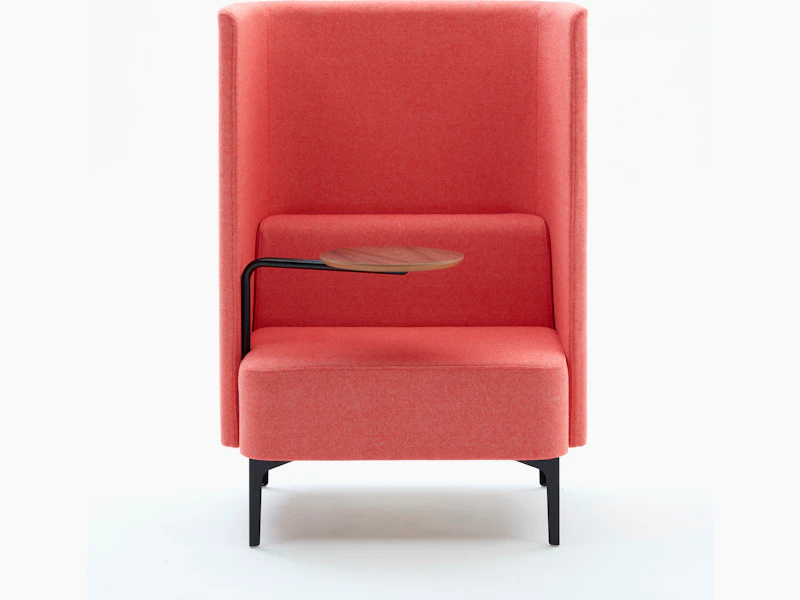 High back Pullman Chair upholstered in pink fabric, with black metal legs, and walnut veneer tablet arm on the right hand side.
