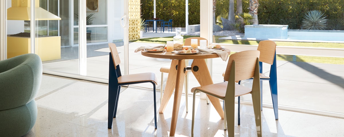 Prouve Gueridon Table & Prouve Standard Chairs in dining room setting overlooking outdoor patio