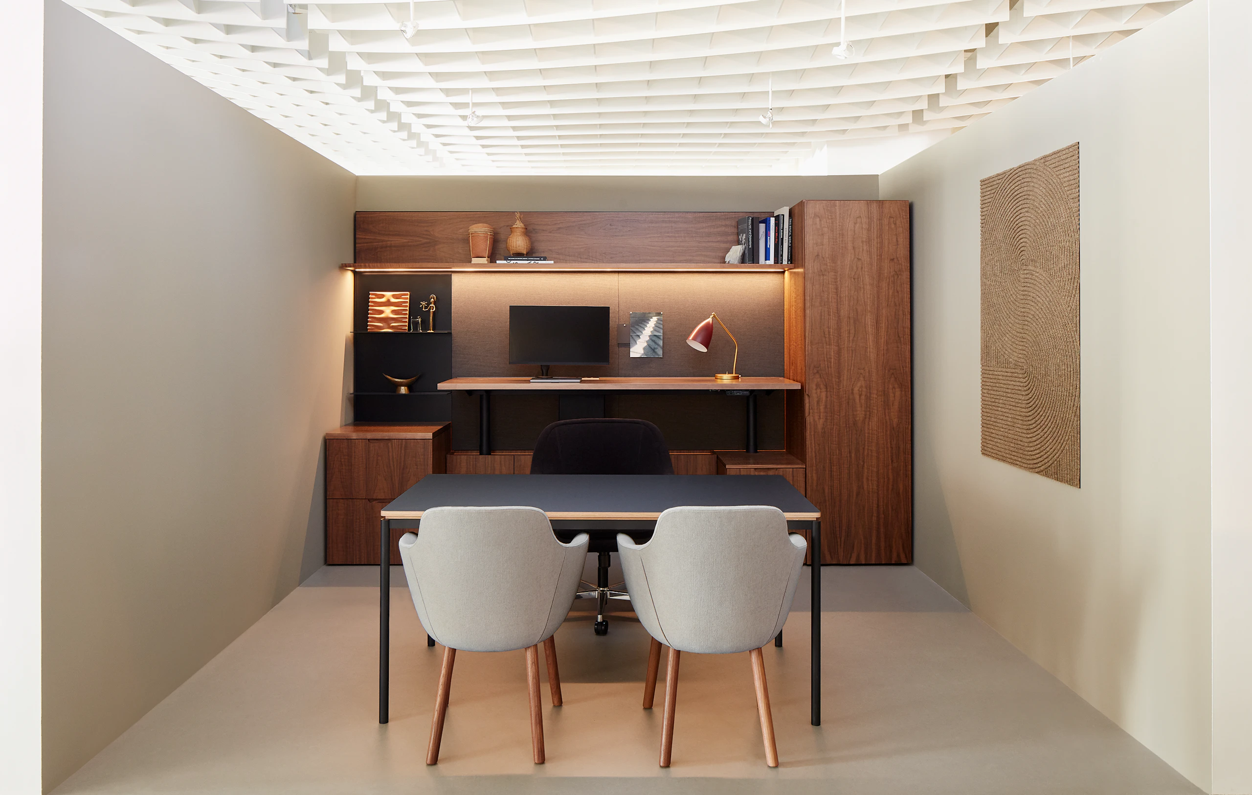 A private office vignette in the Geiger showroom, featuring Geiger One Casegoods with matte black backpainted glass, a Bumper Chair, and Saiba Side Chairs.