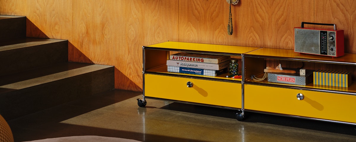 USM Haller Media Console holding books and accessories in a living room setting