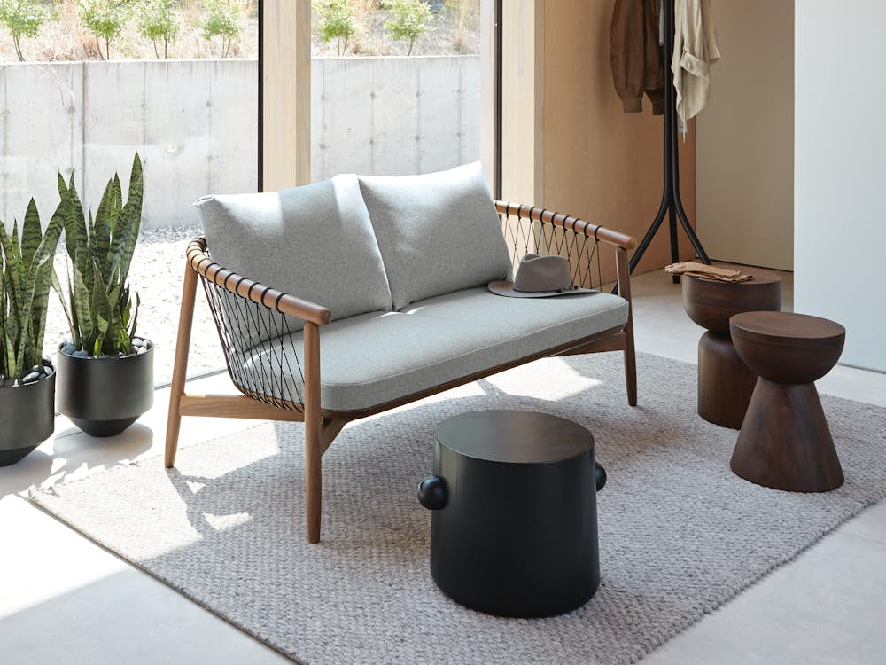 Three Hew Side Tables placed around a Crosshatch Settee in a light, lounge area.