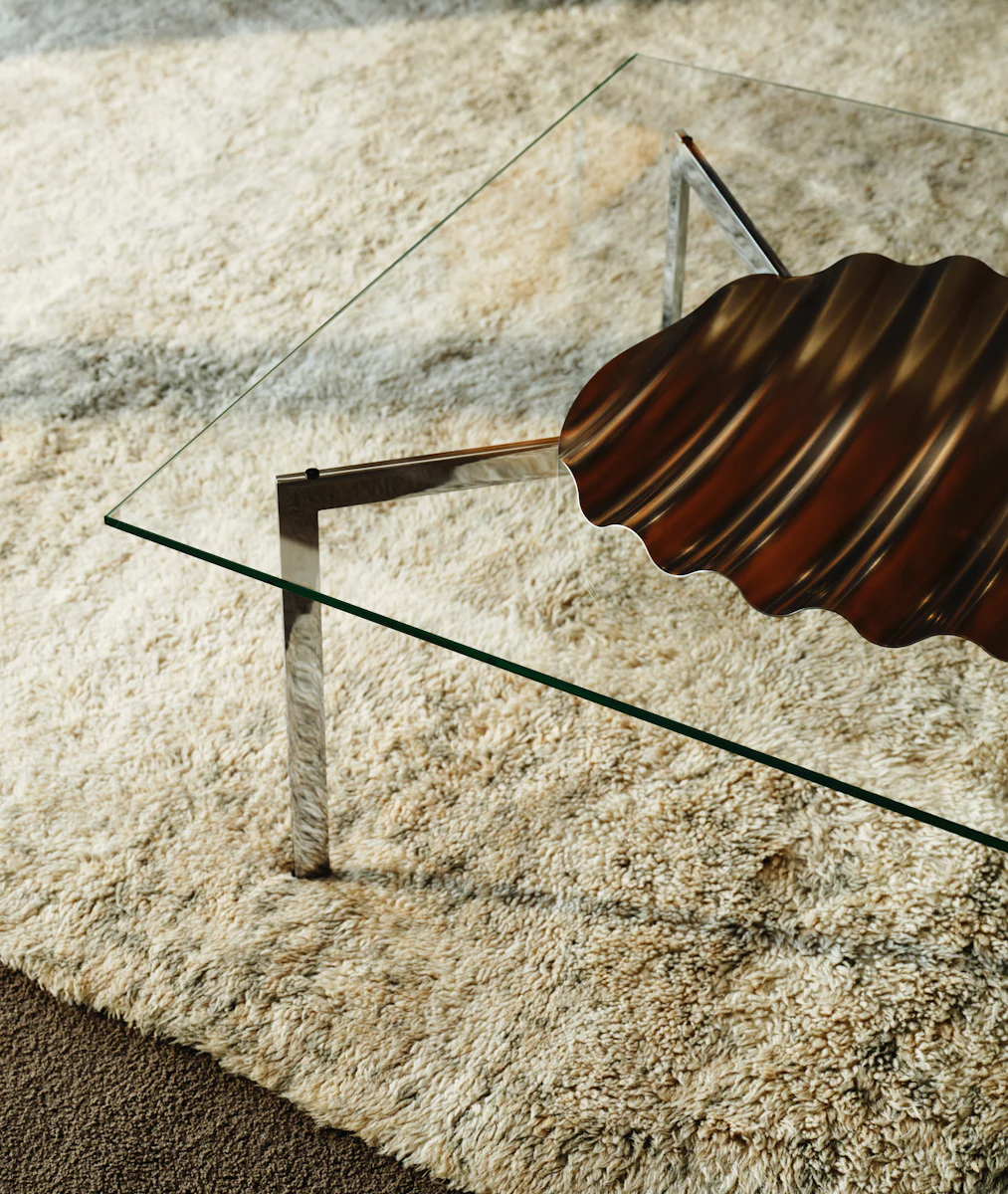 Glass coffee table with overlapping glass panels and metal legs, minimalist design