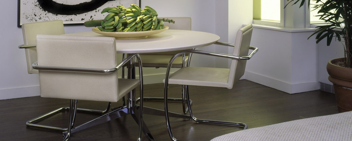 Brno Tubular Chairs surrounding a dining room table with bananas on top of it