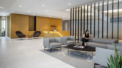 A person waiting on a grey couch in the Blakes law firm reception area