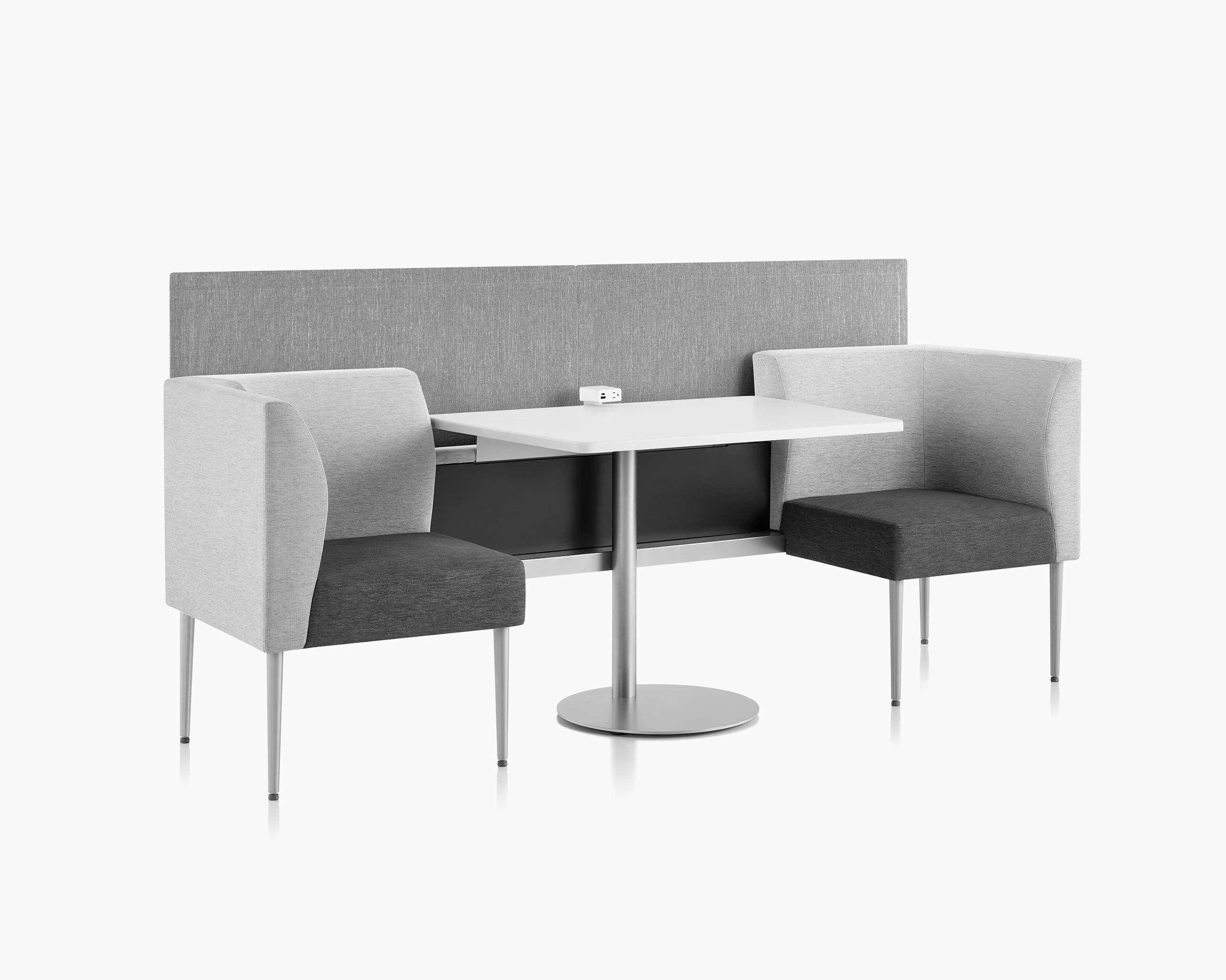 Three-quarter view of Palisade booths with table and power module in the middle and privacy screen.