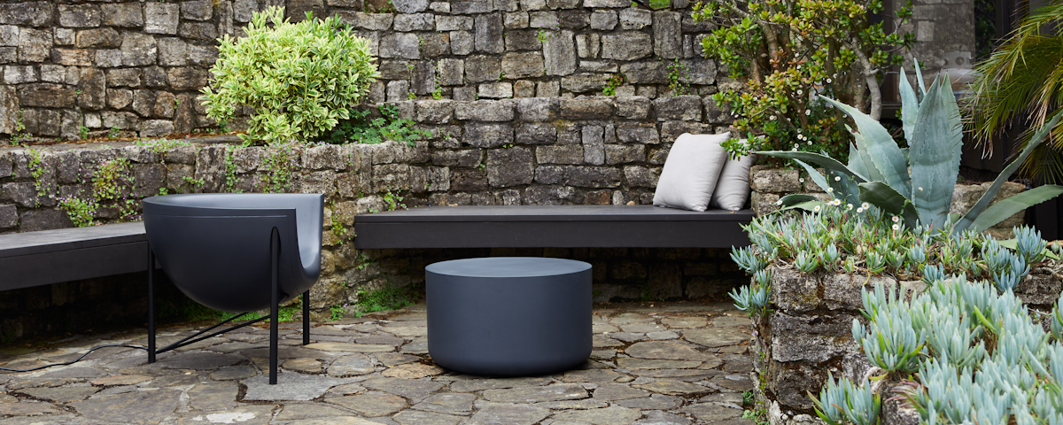 Kosmos Lounge Chair and Kosmos Coffee Table in an outdoor stone patio setting