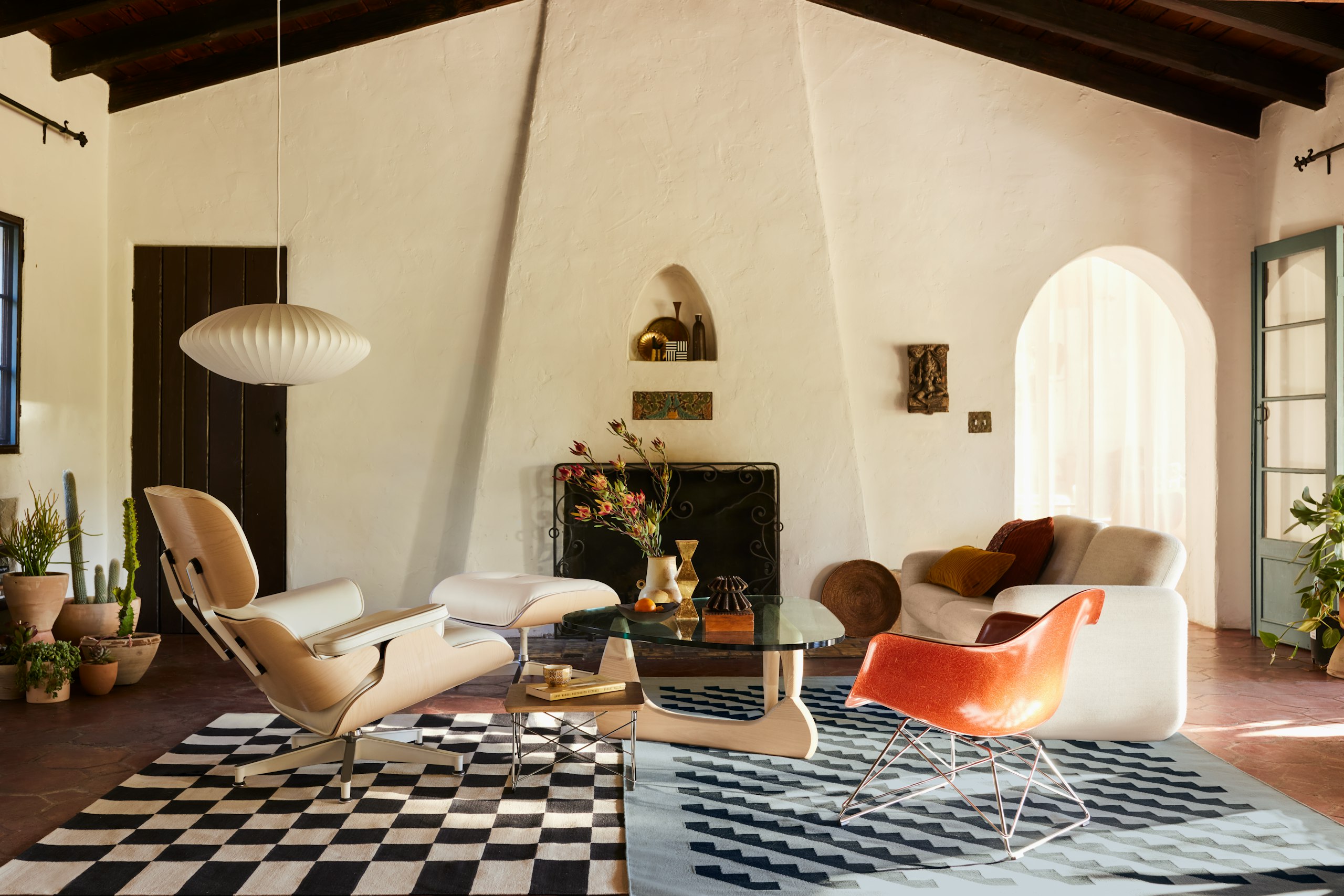 Wilkes Modular Sofa Group Sofa, Girard Steps Rug, Girard Check Rug, Wide Corduroy Pillows, Noguchi Table, Eames Molded Fiberglass Low Wire Base Armchair, Eames Lounge and Ottoman, Eames Wire Low Base Table, and Nelson Saucer Bubble Pendant