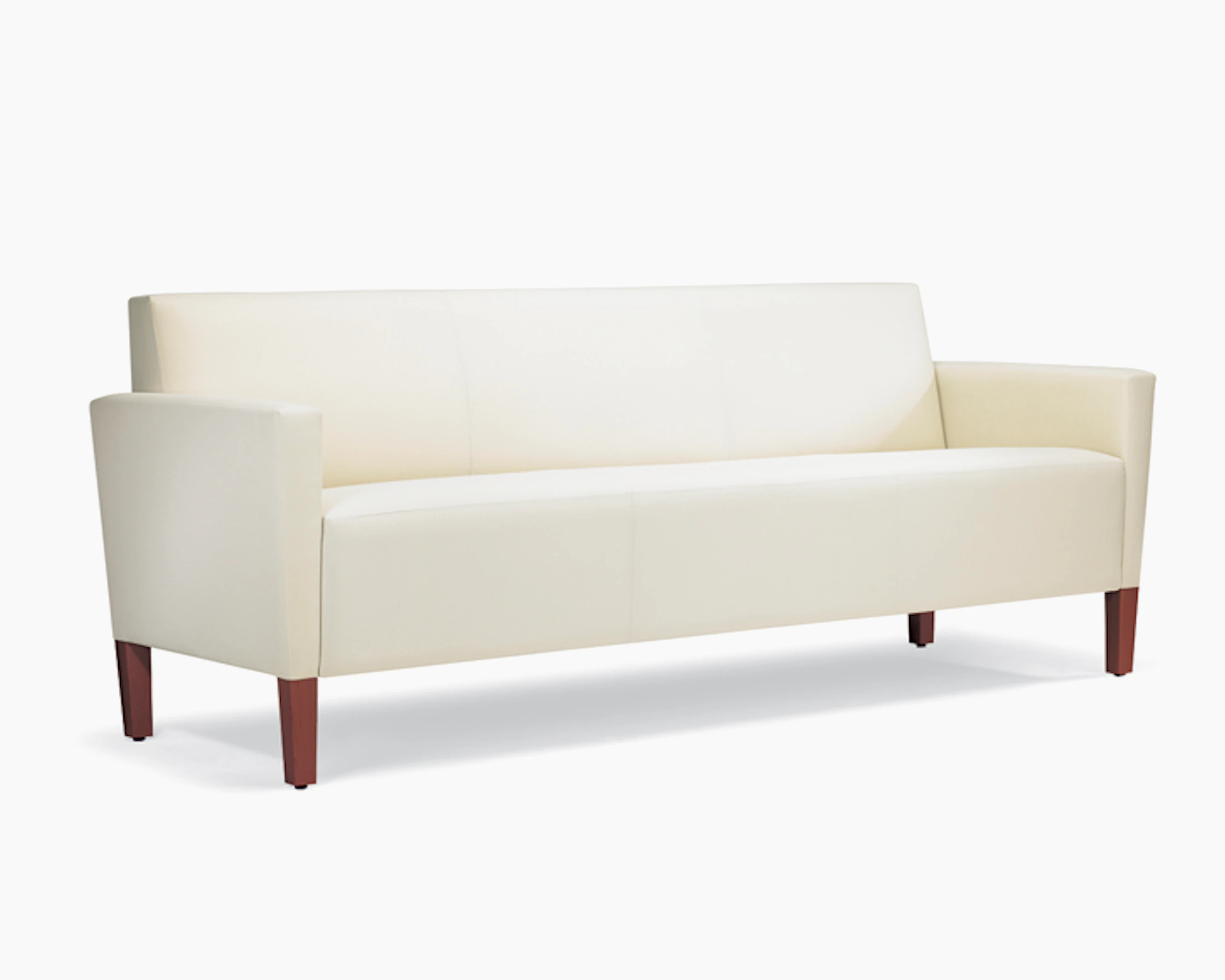 A three-quarter view of a Brava Classic Lounge Sofa with white textile and upholstered arm caps.
