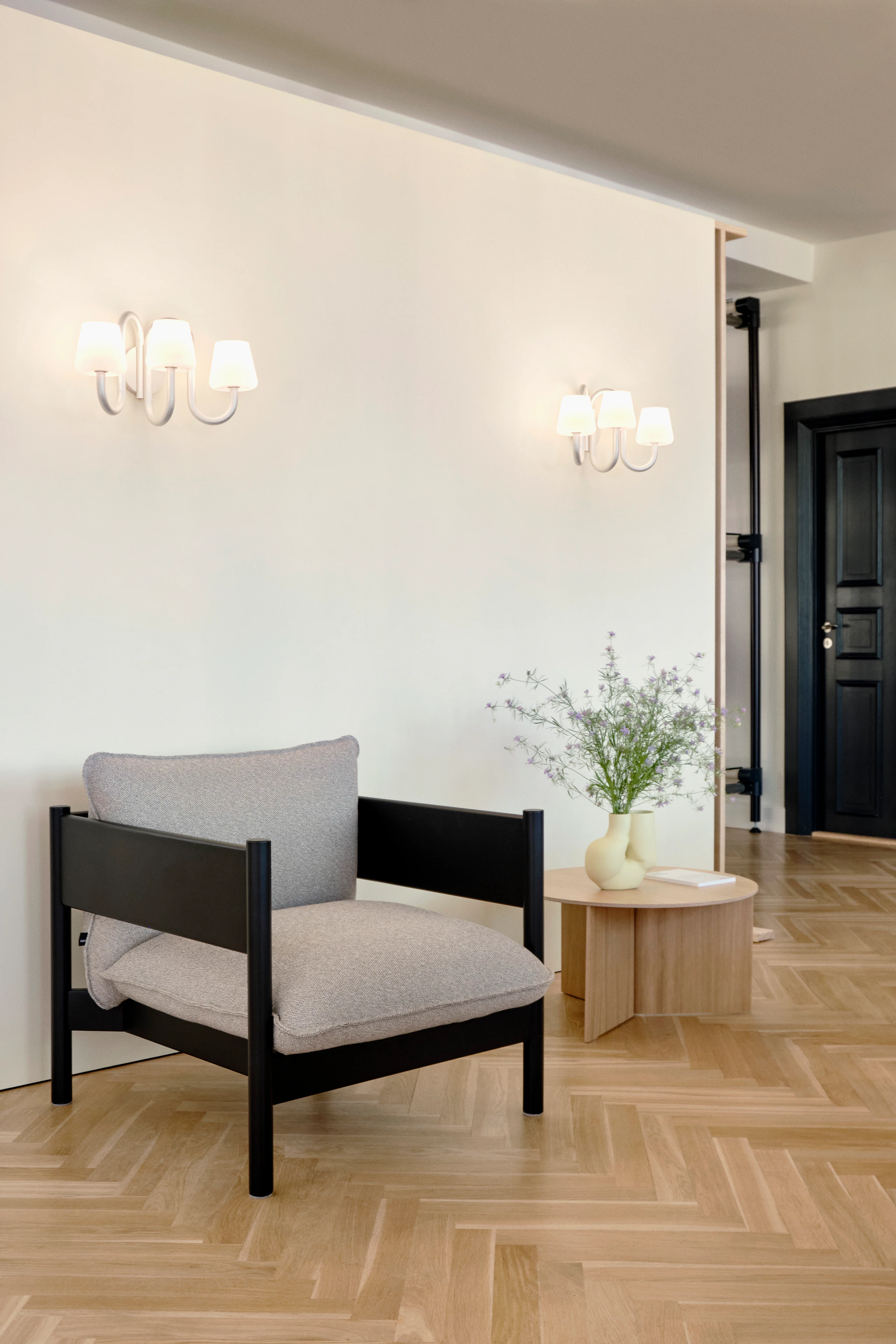 Arbour Club Armchair with black base and grey upholstery next to Slit Wood Coffee Table