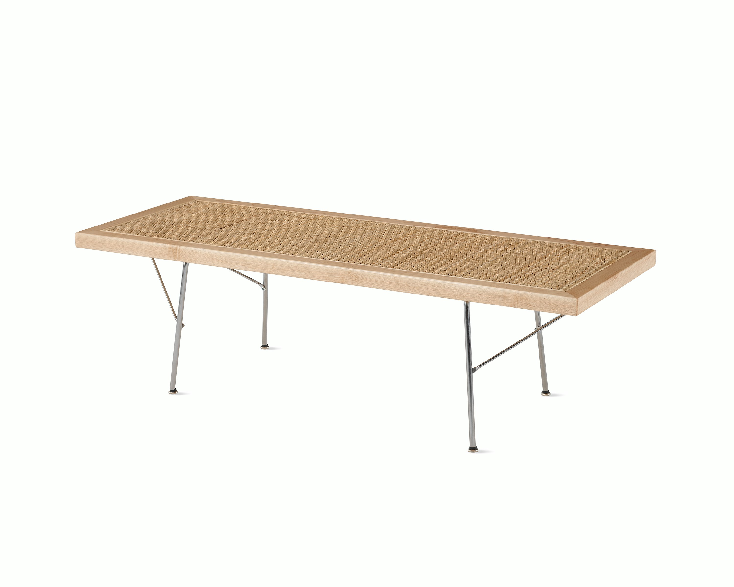 A Nelson Cane Bench with a maple frame and metal base, viewed from the side at an angle.