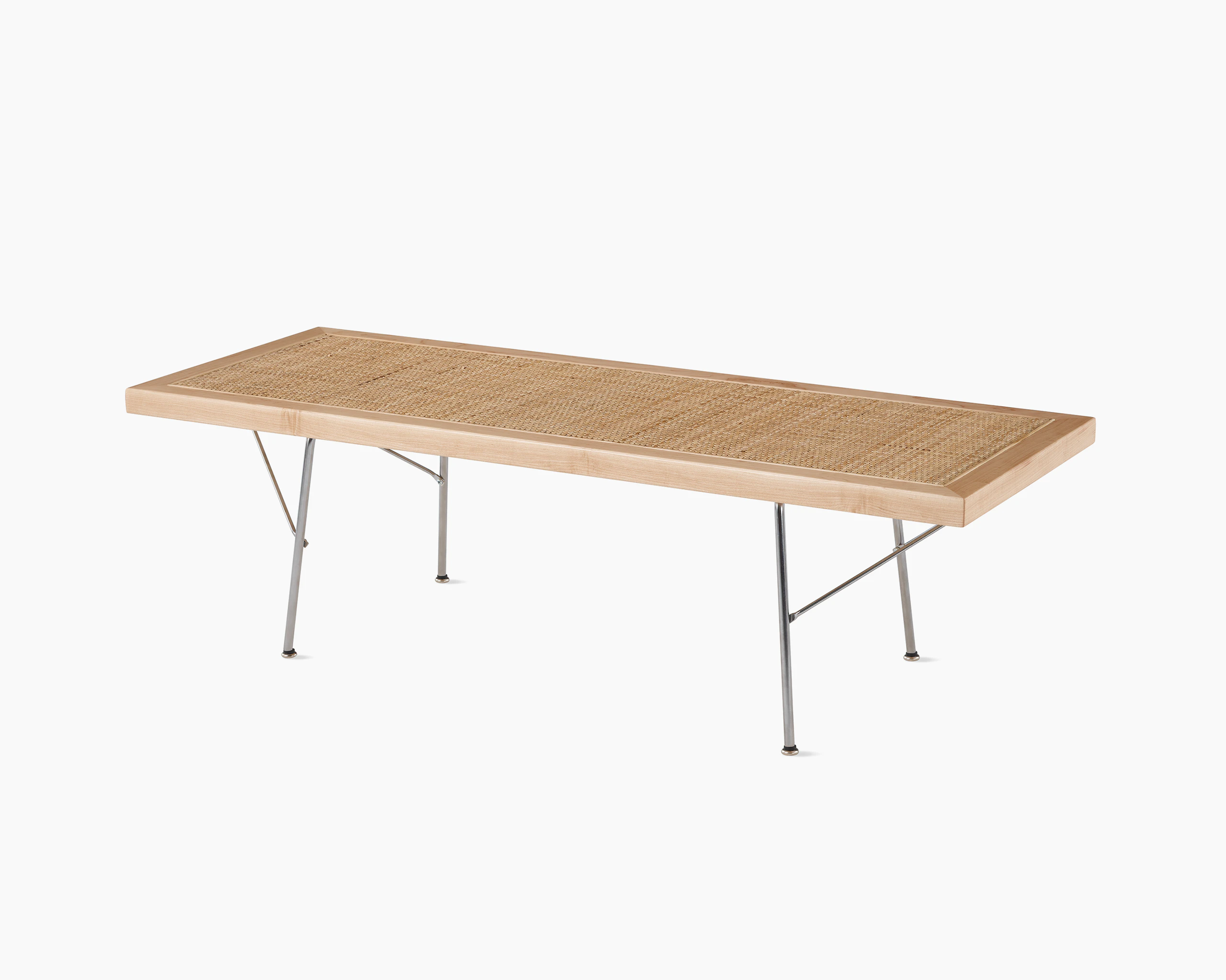 A Nelson Cane Bench with a maple frame and metal base, viewed from the side at an angle.