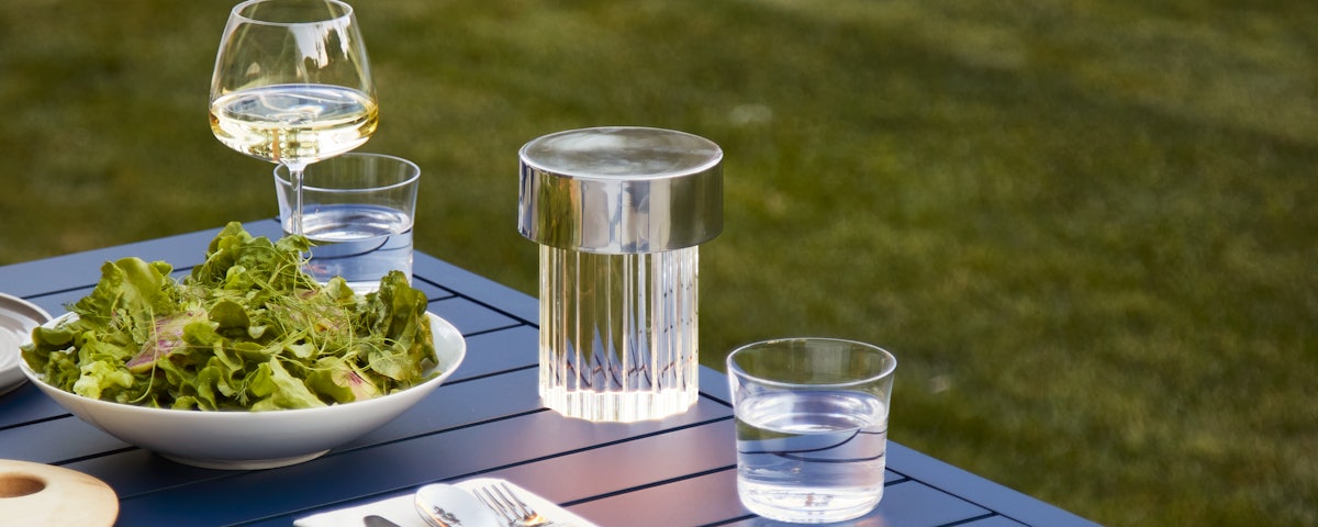 Last Order Portable Light on an Eos Outdoor Dining Table with glasses, plates and silverware