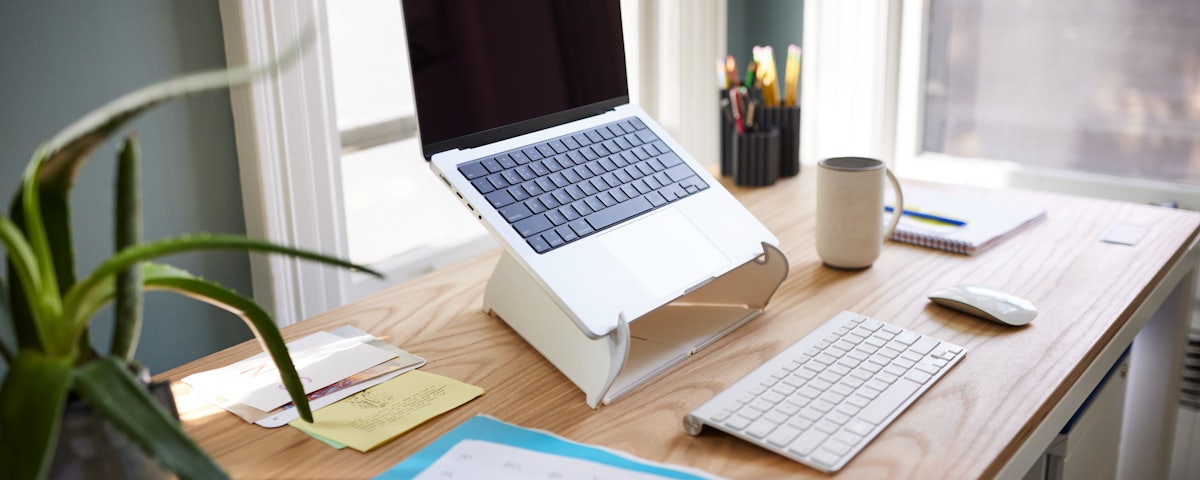 Oripura Laptop Stand holding a laptop on a desk in a home office setting