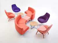 An orange patterned single Symbol Bench joining two orange 90 degree Symbol Modular Seating pieces with four Always Lounge Chairs.