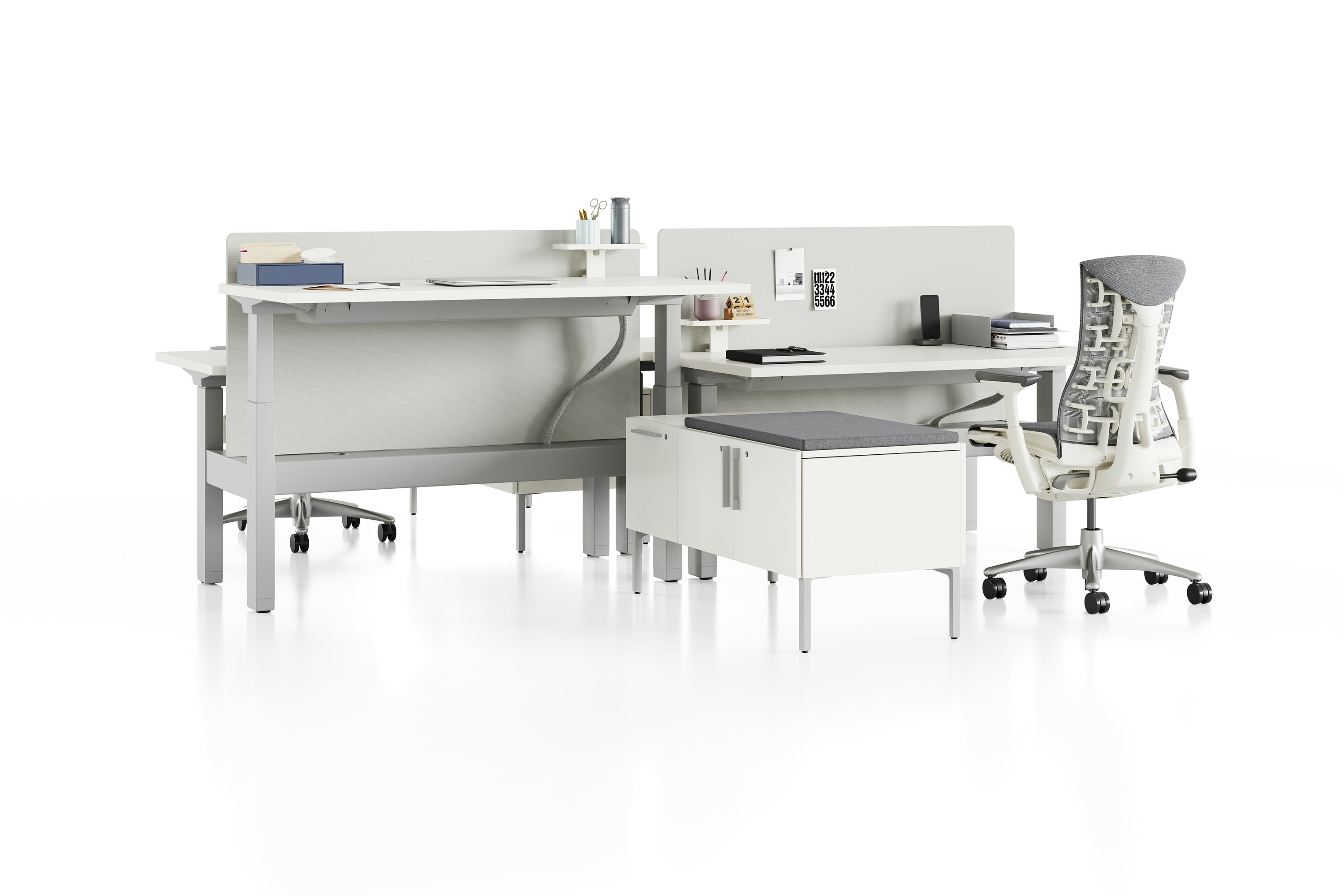 Standing desk system, Renew Link, with rectangular work surfaces, Embody Chairs and privacy screens. One of four desks are raised to standing height.