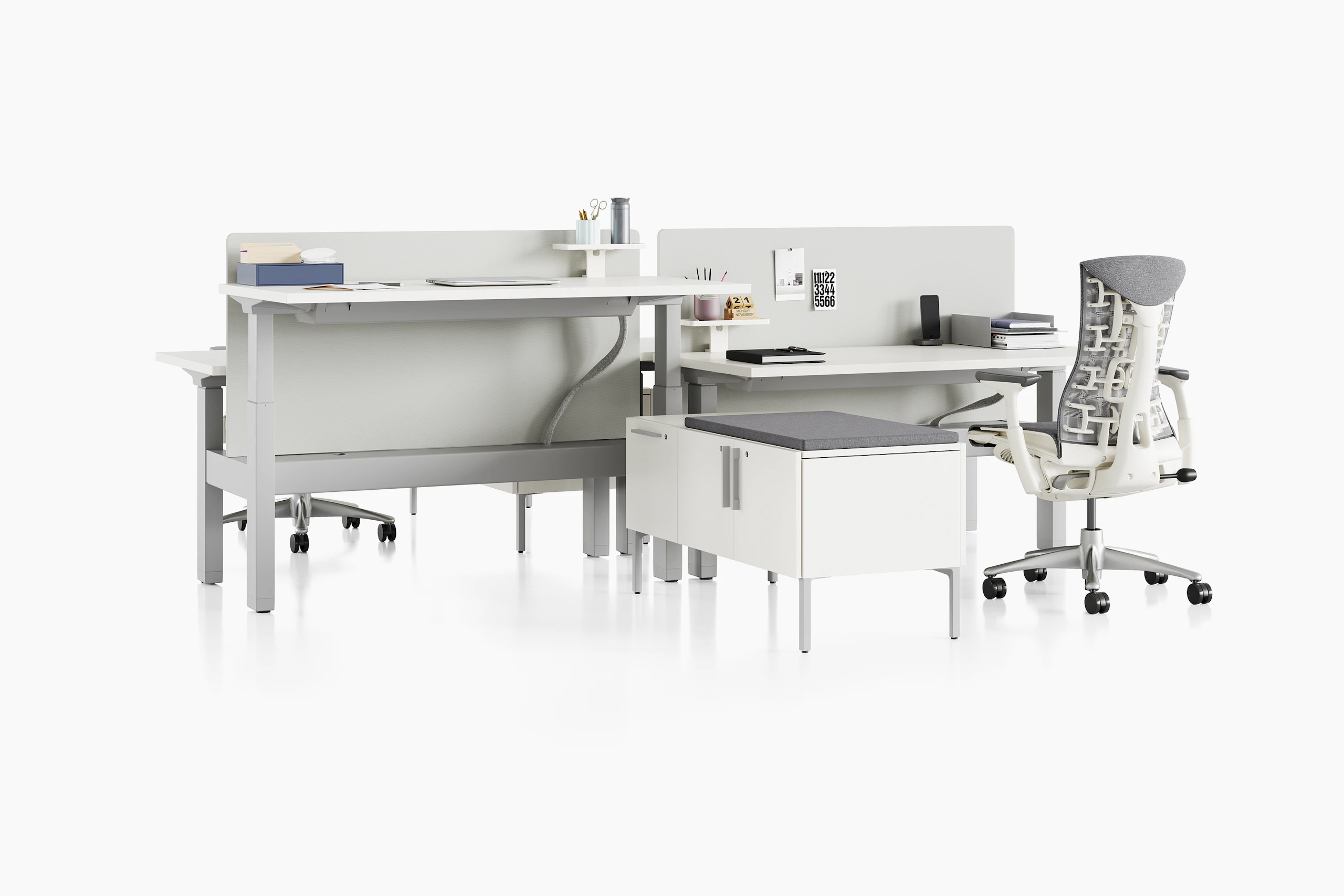 Standing desk system, Renew Link, with rectangular work surfaces, Embody Chairs and privacy screens. One of four desks are raised to standing height.