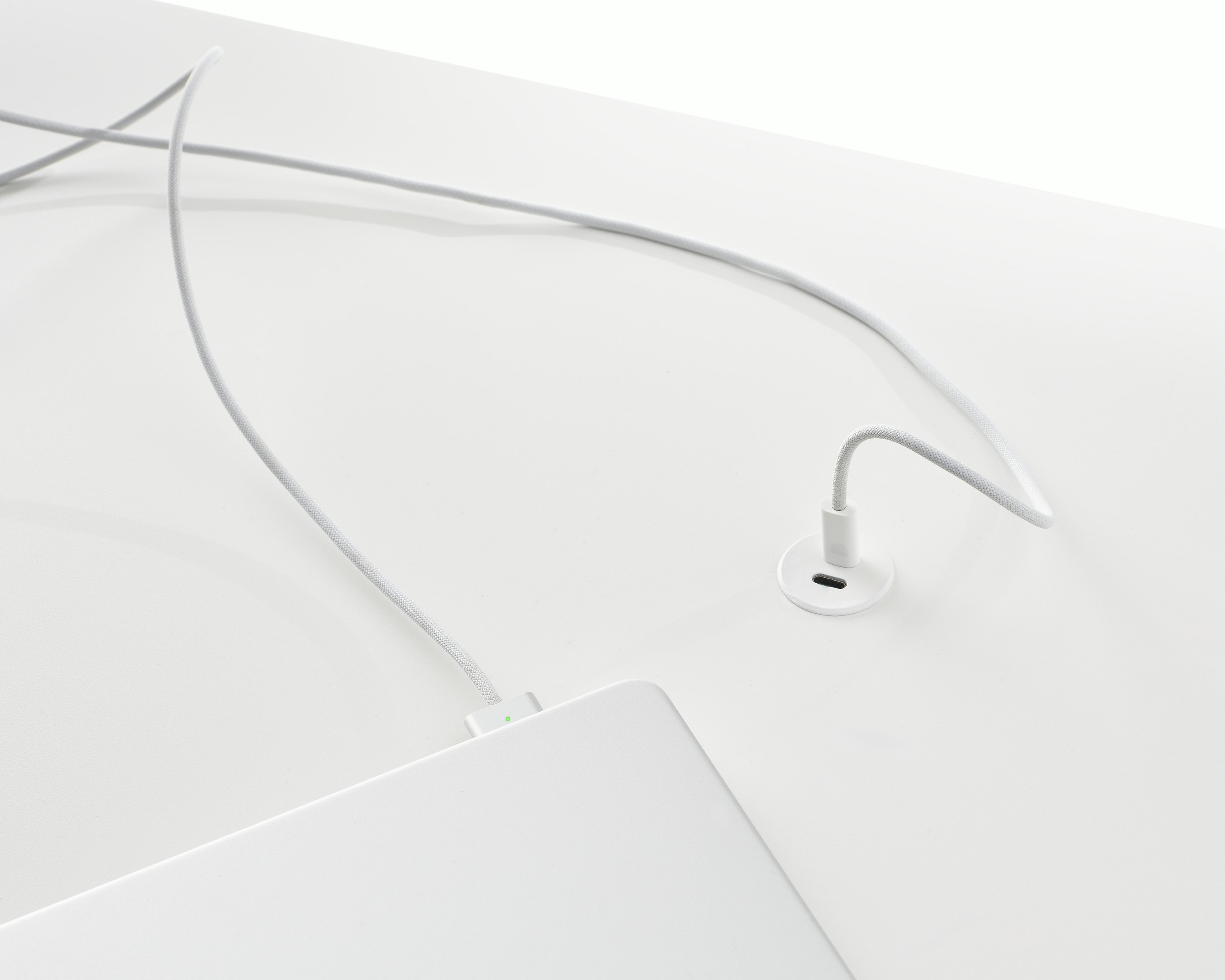 Surface-integrated dual port USB-C power solution charging a laptop shown in white.