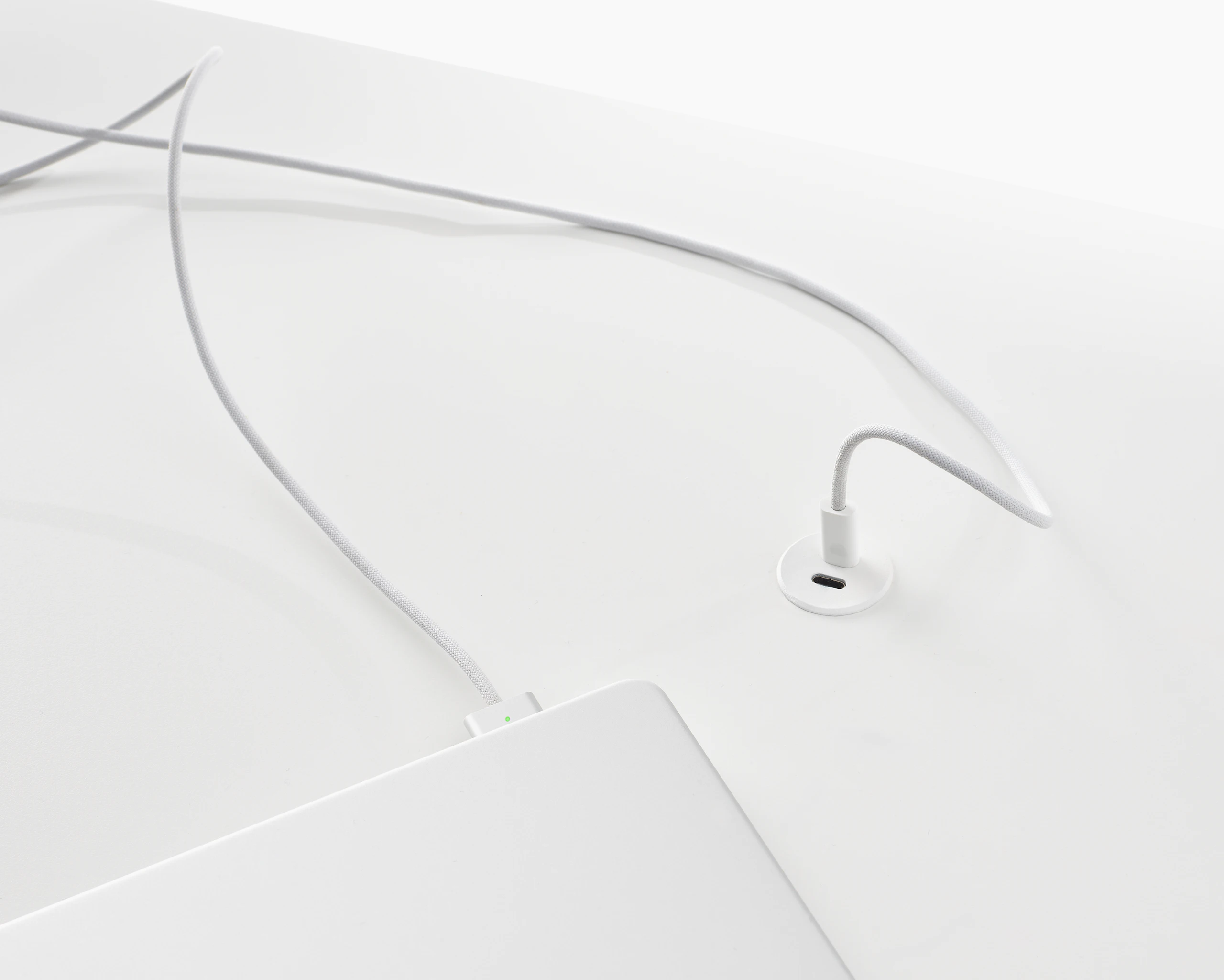Surface-integrated dual port USB-C power solution charging a laptop shown in white.