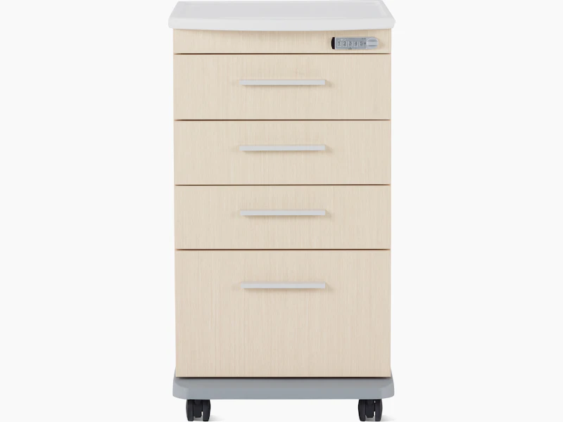 Front view of a Mora casework four-drawer supply cart in a light ash finish and a white solid surface top.