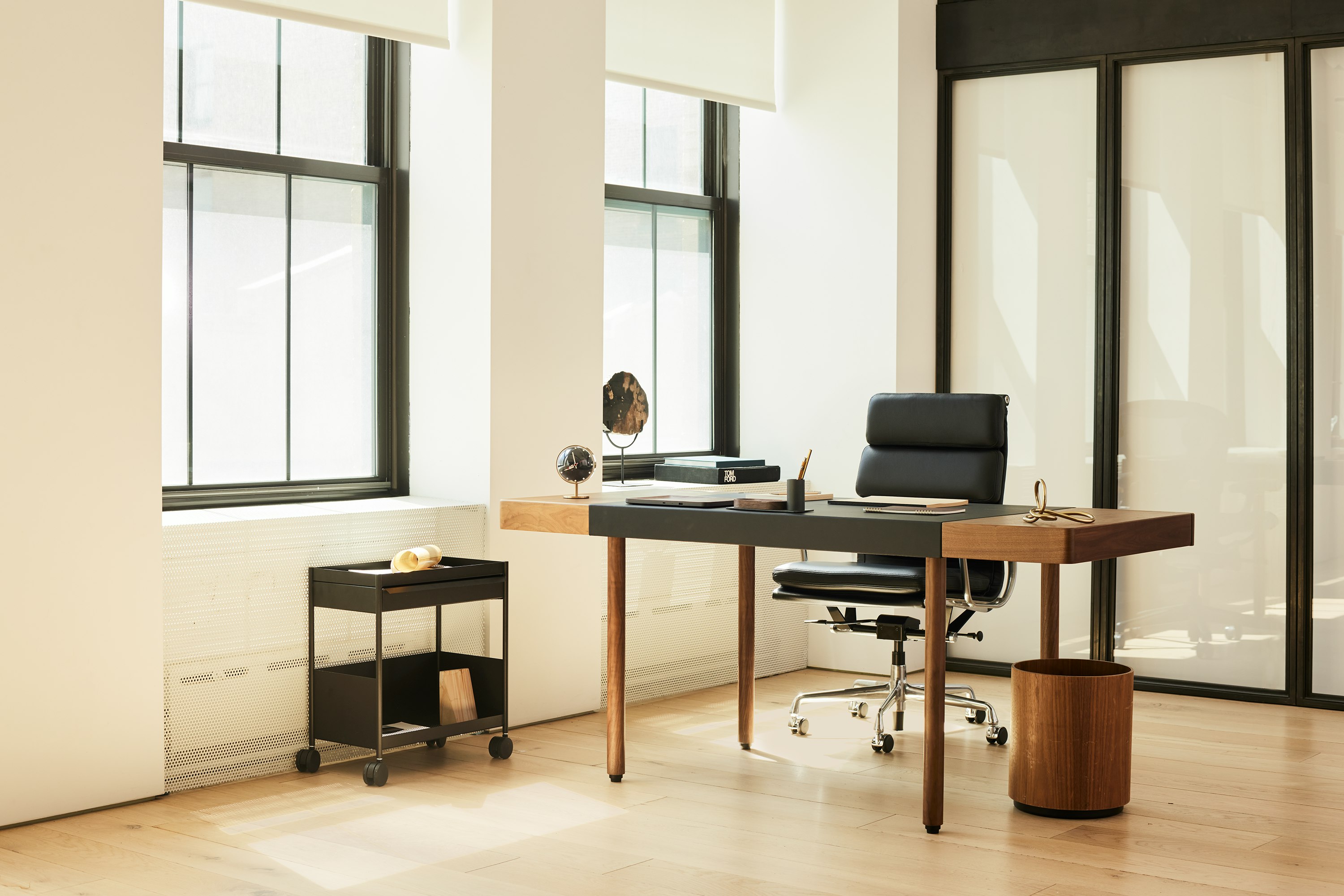 A corporate office setting with the New Canaan Leatherwrap Sit-to-Stand Desk and Eames Soft Pad chair.