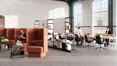 An individual reading in a burnt-orange NaughtOne Pullman chair next to Herman Miller OE1 Storage Trolleys in an individual study hall setting designed to cultivate an area of focus and wellbeing