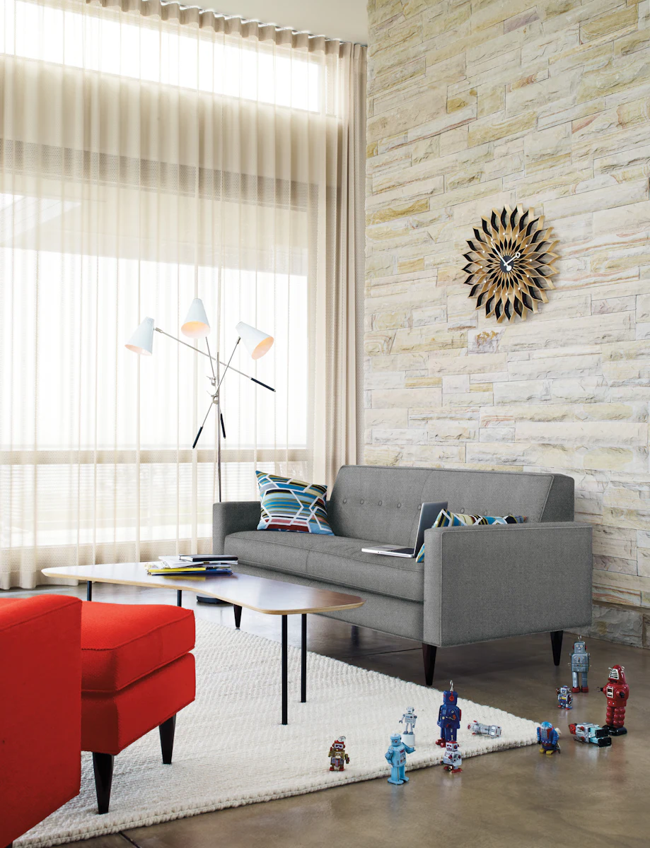Living room scene featuring gray sofa, round coffee tables, and kids toy figures.